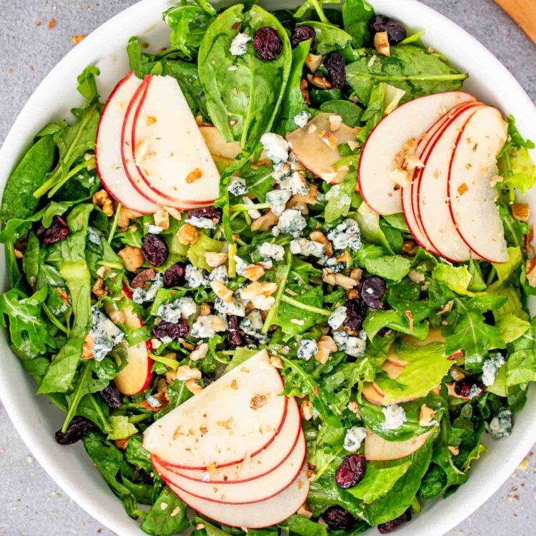 fresh apple walnut salad in a white serving bowl.