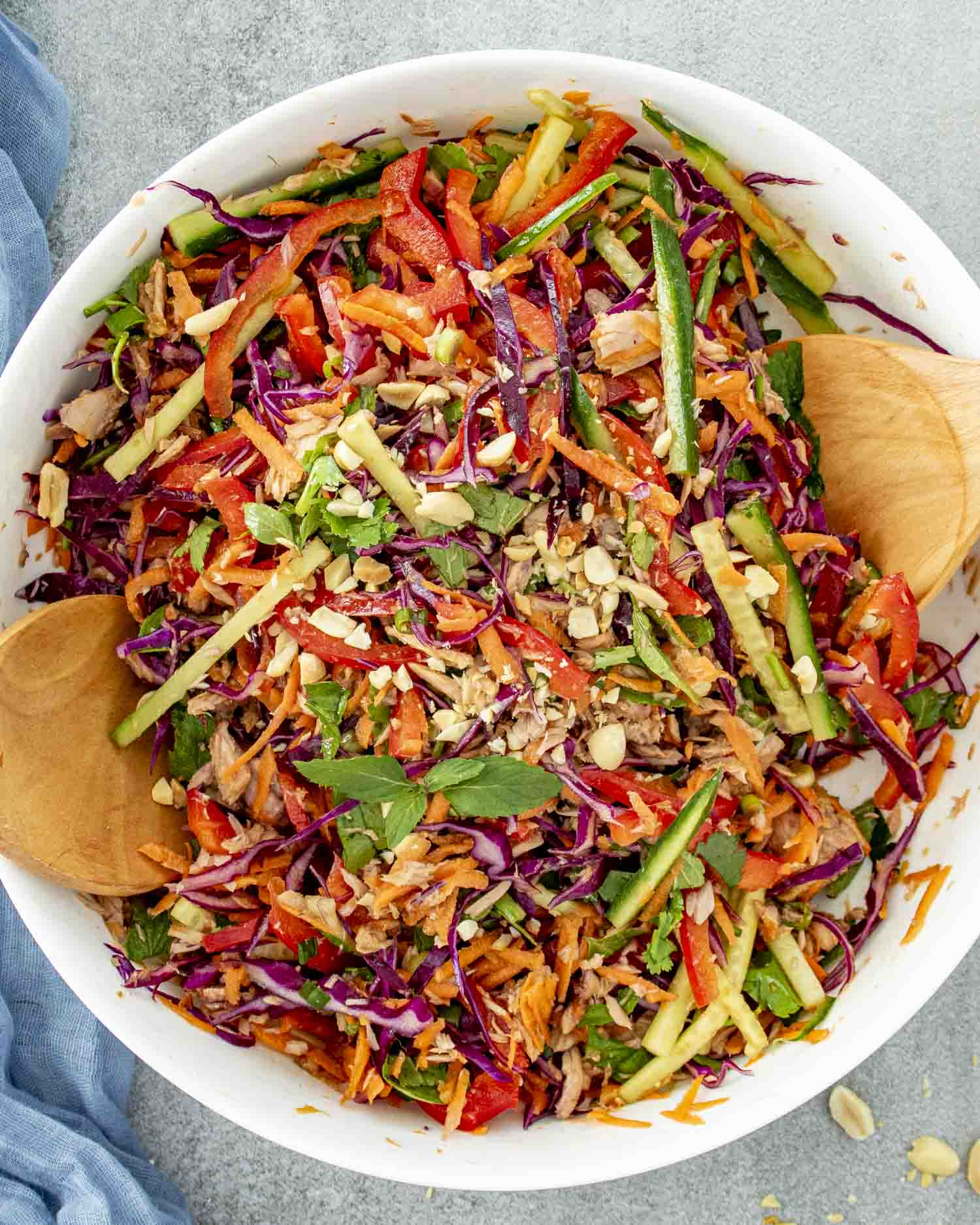 fresh Asian Tuna Salad in a white bowl with 2 wooden spoons inside.