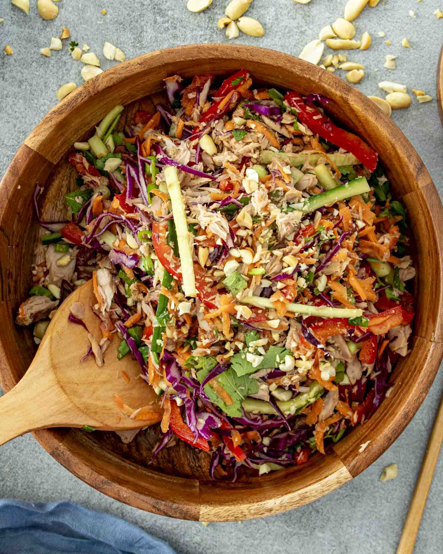 fresh asian tuna salad in a wooden bowl with a wooden spoon inside.