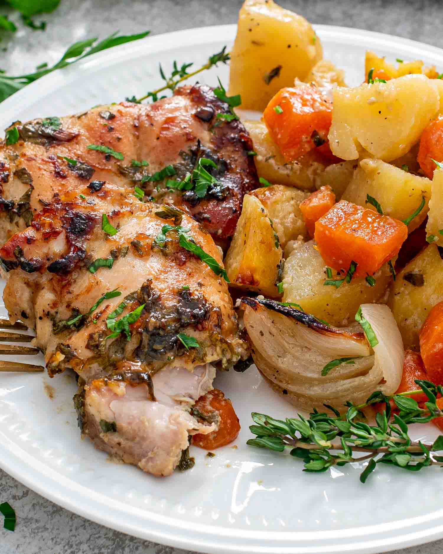 a serving of baked honey mustard chicken with potatoes on a white plate.