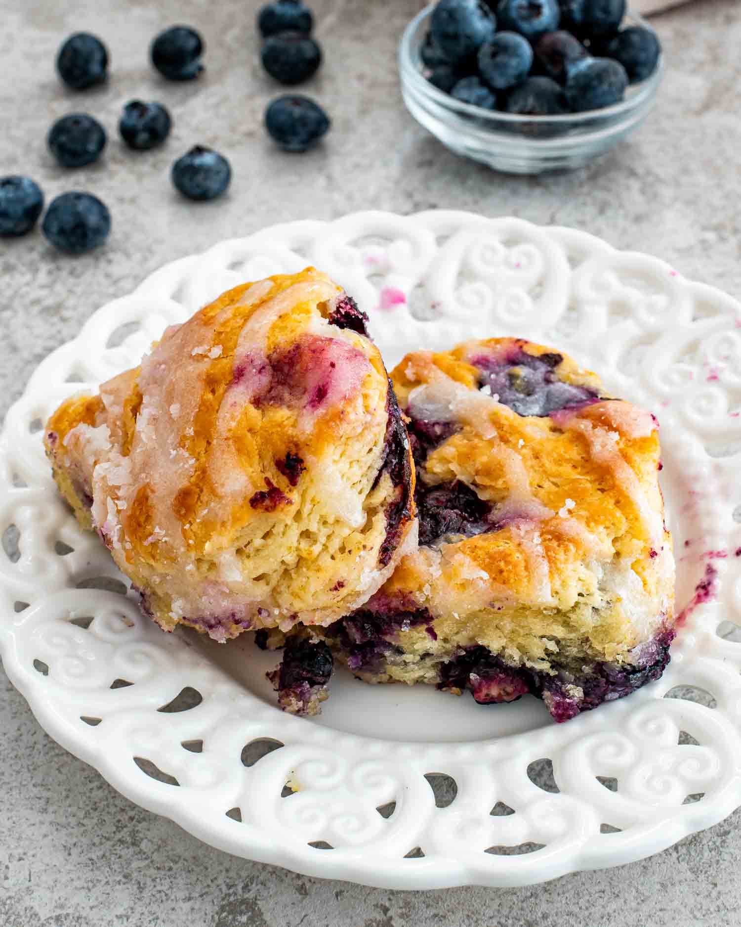 2 blueberry biscuits on a white plate.