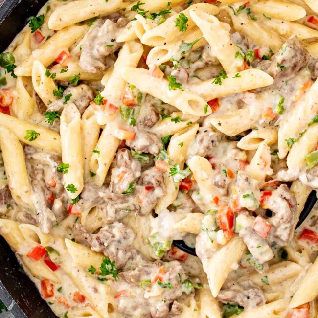 creamy cheesy cheesesteak pasta in a skillet.