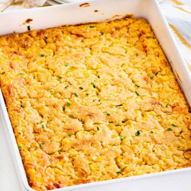 closeup of corn casserole in a white casserole dish.