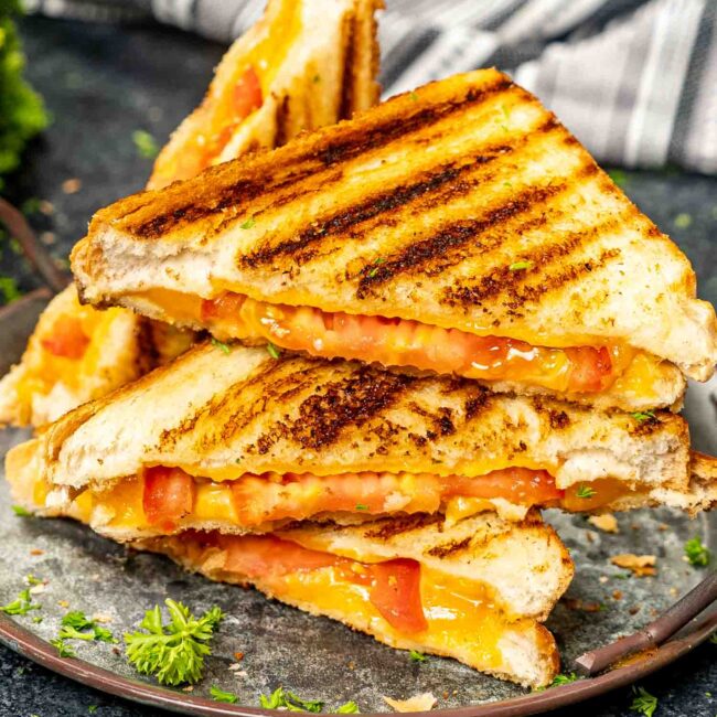 grilled cheese sandwich cut in half on a plate.