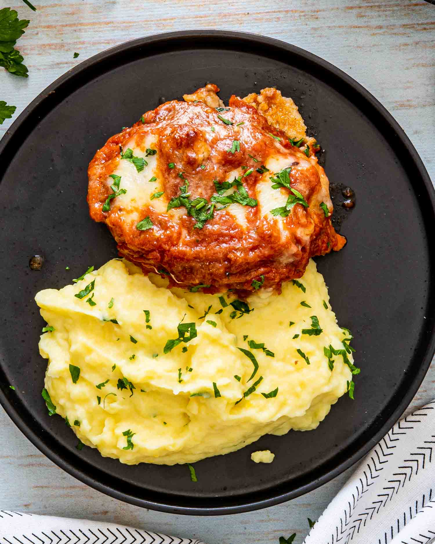 italian hamburger steak over a bed of mashed potatoes.