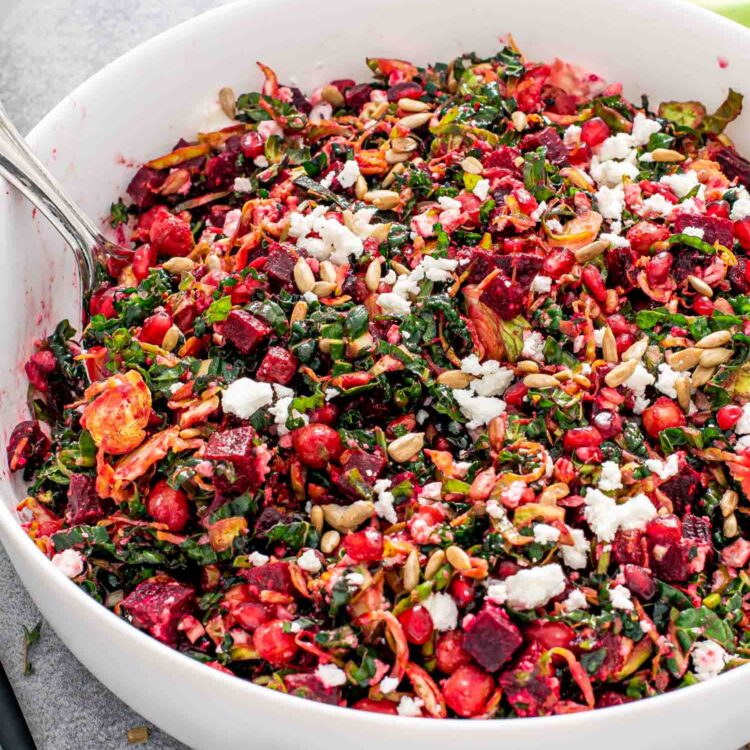 kale and brussels sprouts salad in a white bowl.