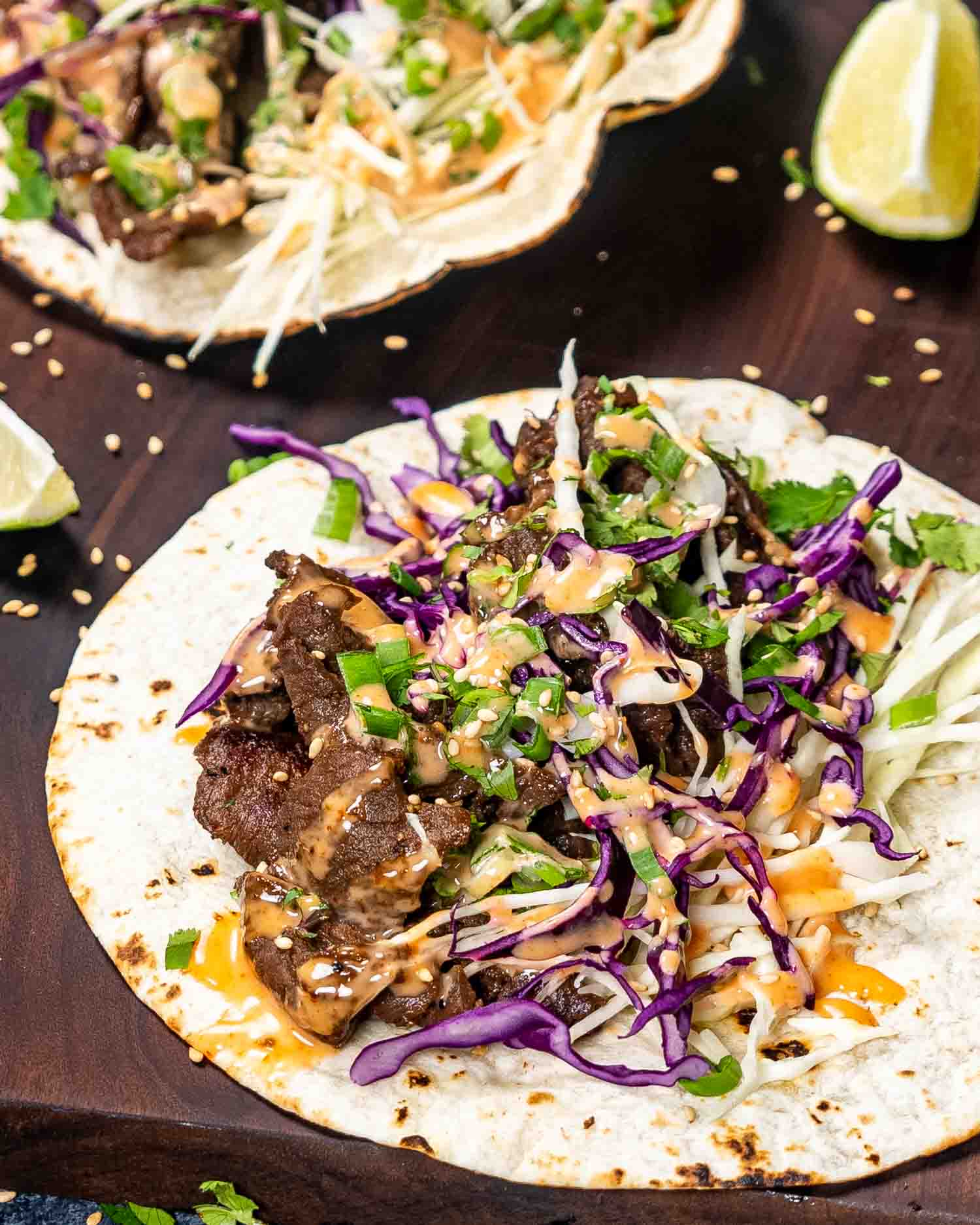 korean beef tacos on a wooden cutting board.