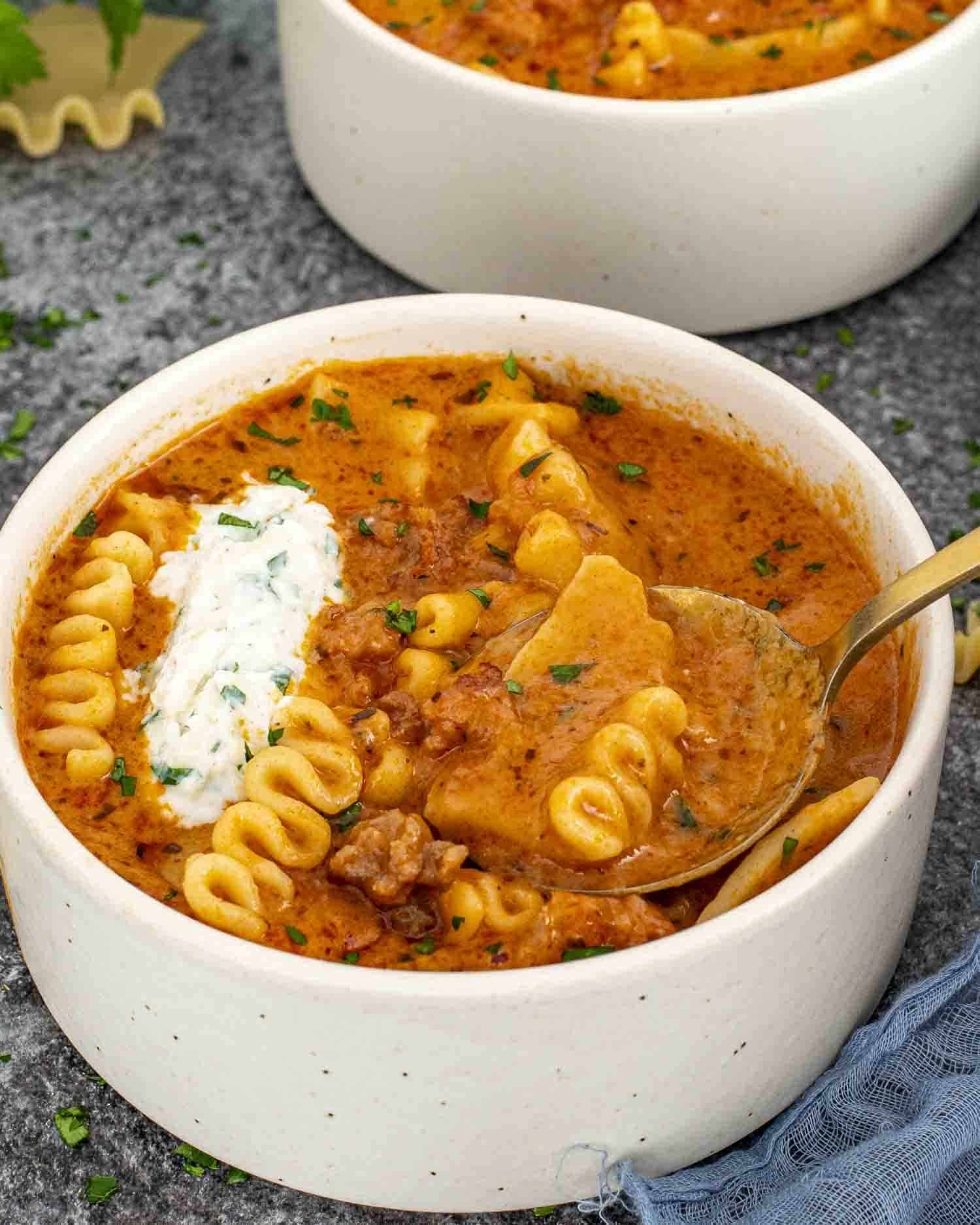 a bowl of lasagna soup with a dollop or ricotta and mozzarella cheese mixture.