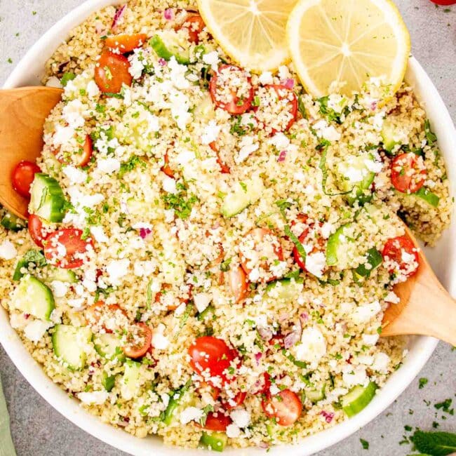 freshly made lemon cucumber couscous salad in a white bowl.