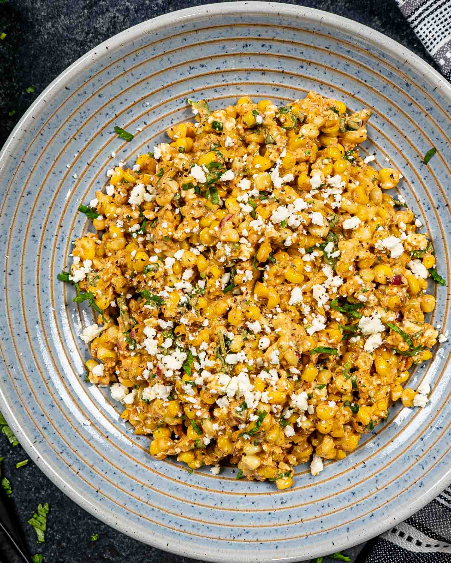 freshly made (mexican street corn salad in a blue bowl.