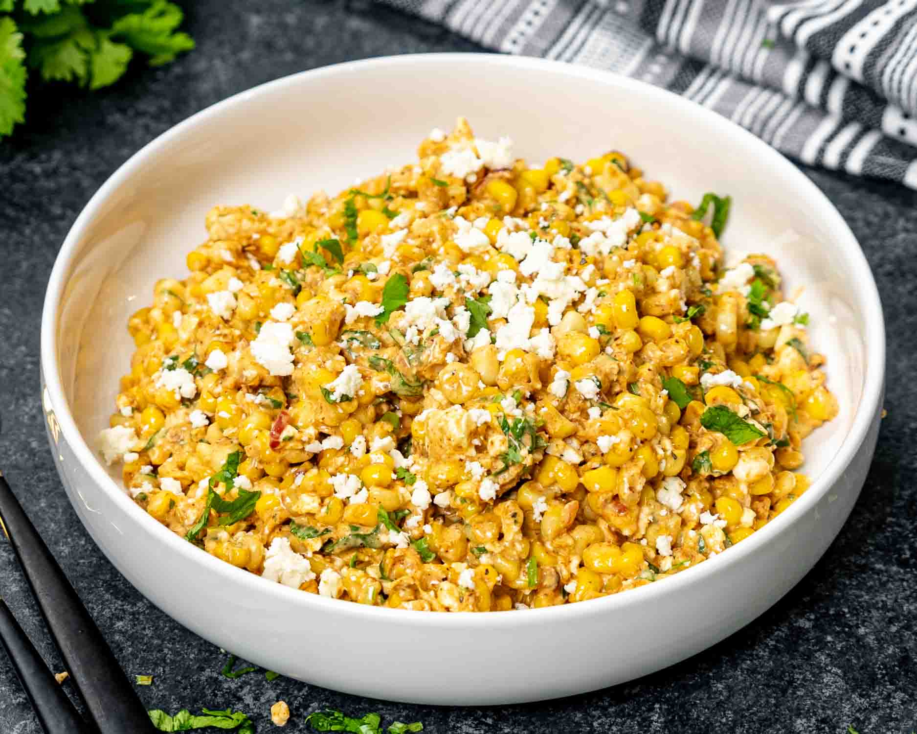 freshly made (mexican street corn salad in a white bowl.