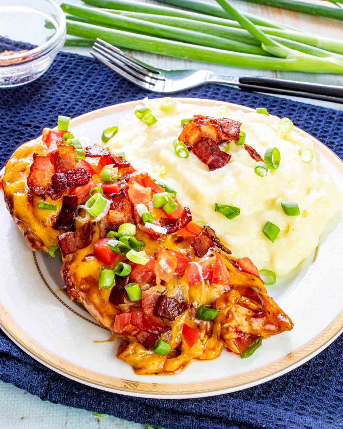 a monterey chicken breast with mashed potatoes on a plate.