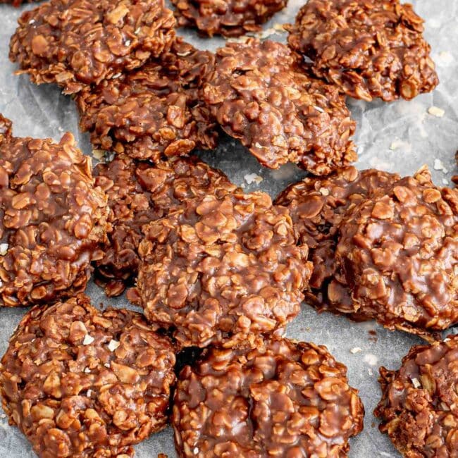 a bunch of no bake chocolate oatmeal cookies on a piece of parchment paper.