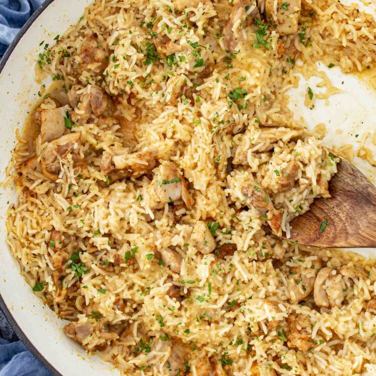 garlic butter chicken and rice in a braiser garnished with parsley.