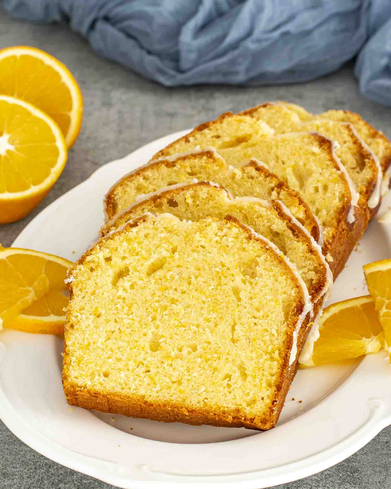 Slices of orange cake arranged on a white plate, showcasing its moist texture and golden color.