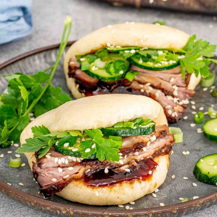 freshly made pork belly bao buns on a metal plate.