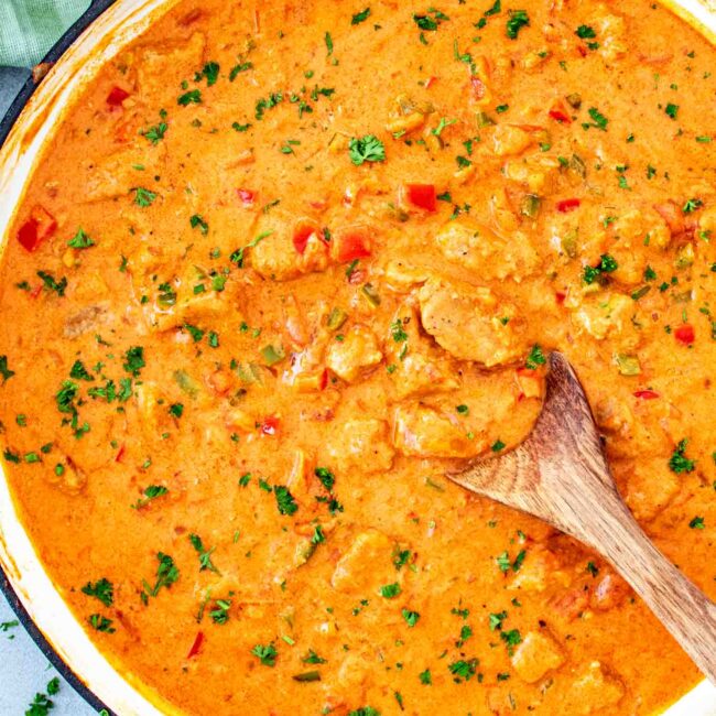 freshly made pork paprikash in a pot garnished with parsley.