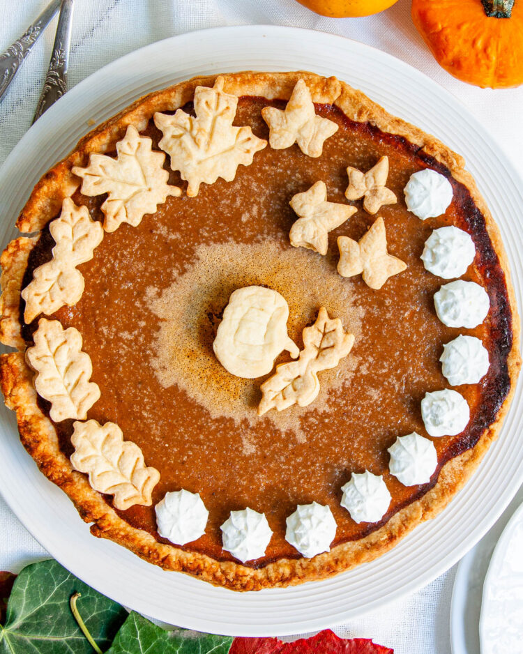 overhead shot of a baked pumpkin pie on a white serving plate