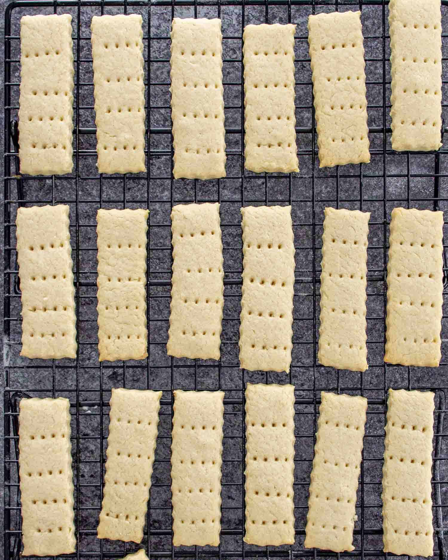 freshly baked shortbread cookies cooling on a black cooling rack.