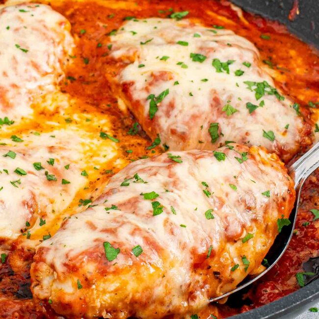 skillet chicken parmesan garnished with parsley.