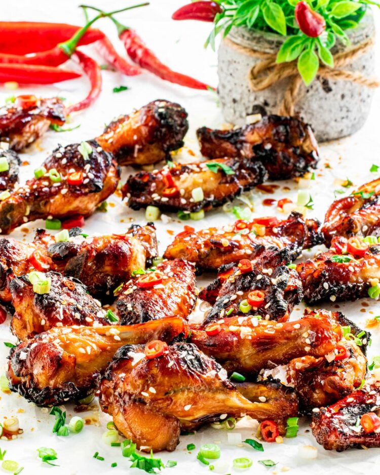 a bunch of baked chicken wings on parchment paper