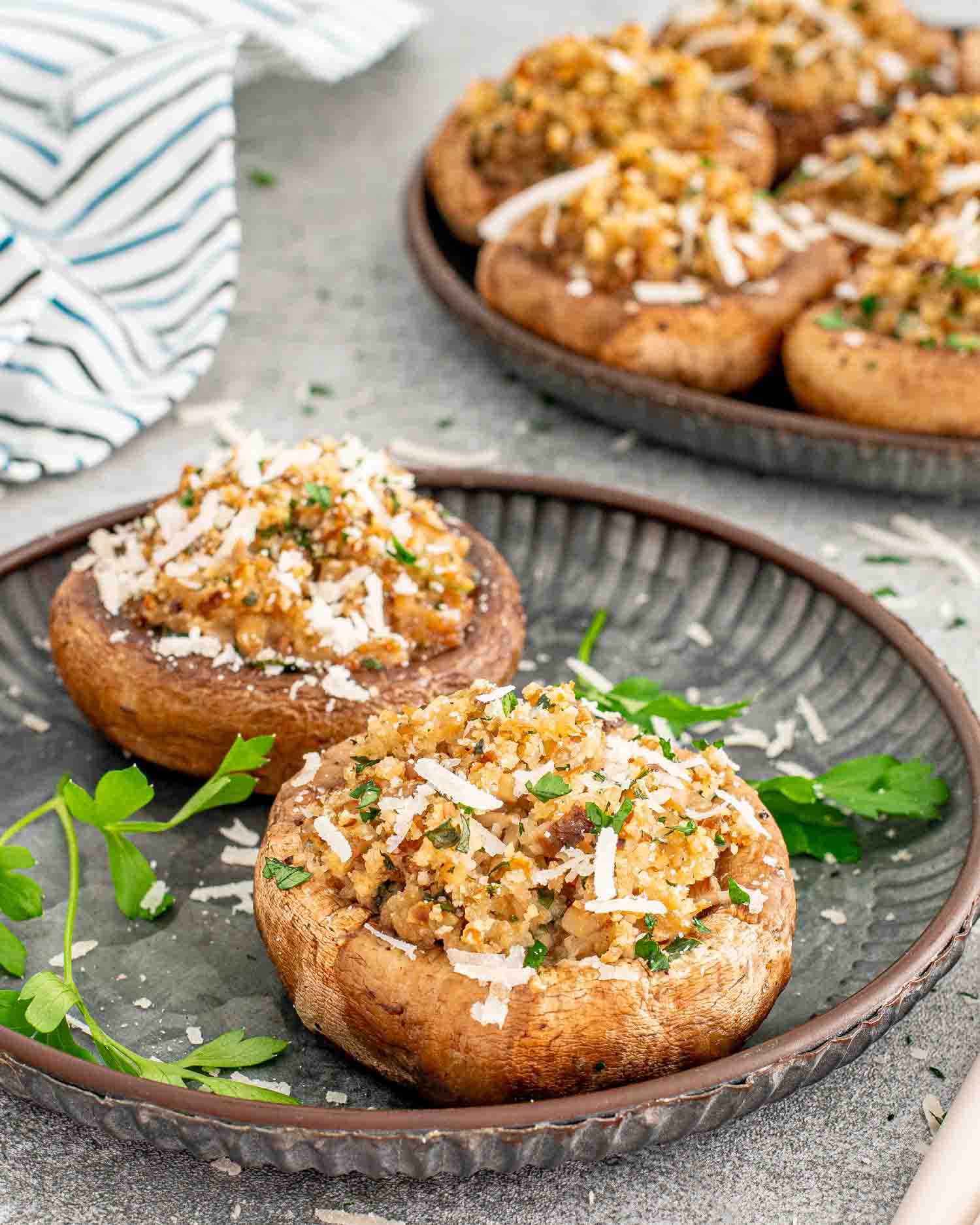 two stuffed mushrooms on a metal plate.