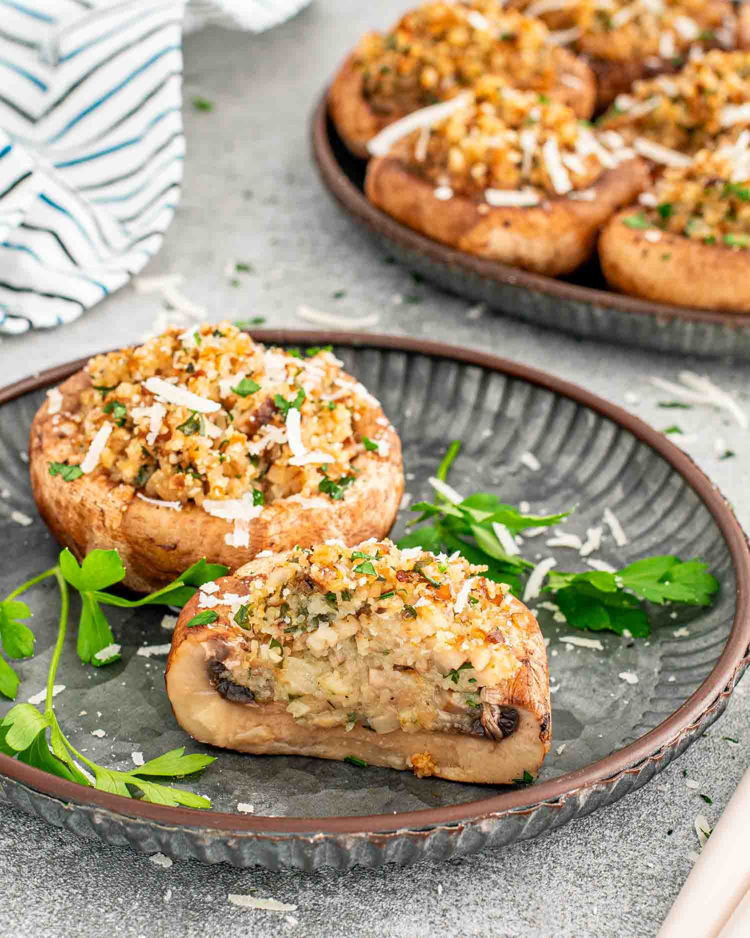 two stuffed mushrooms on a metal plate.