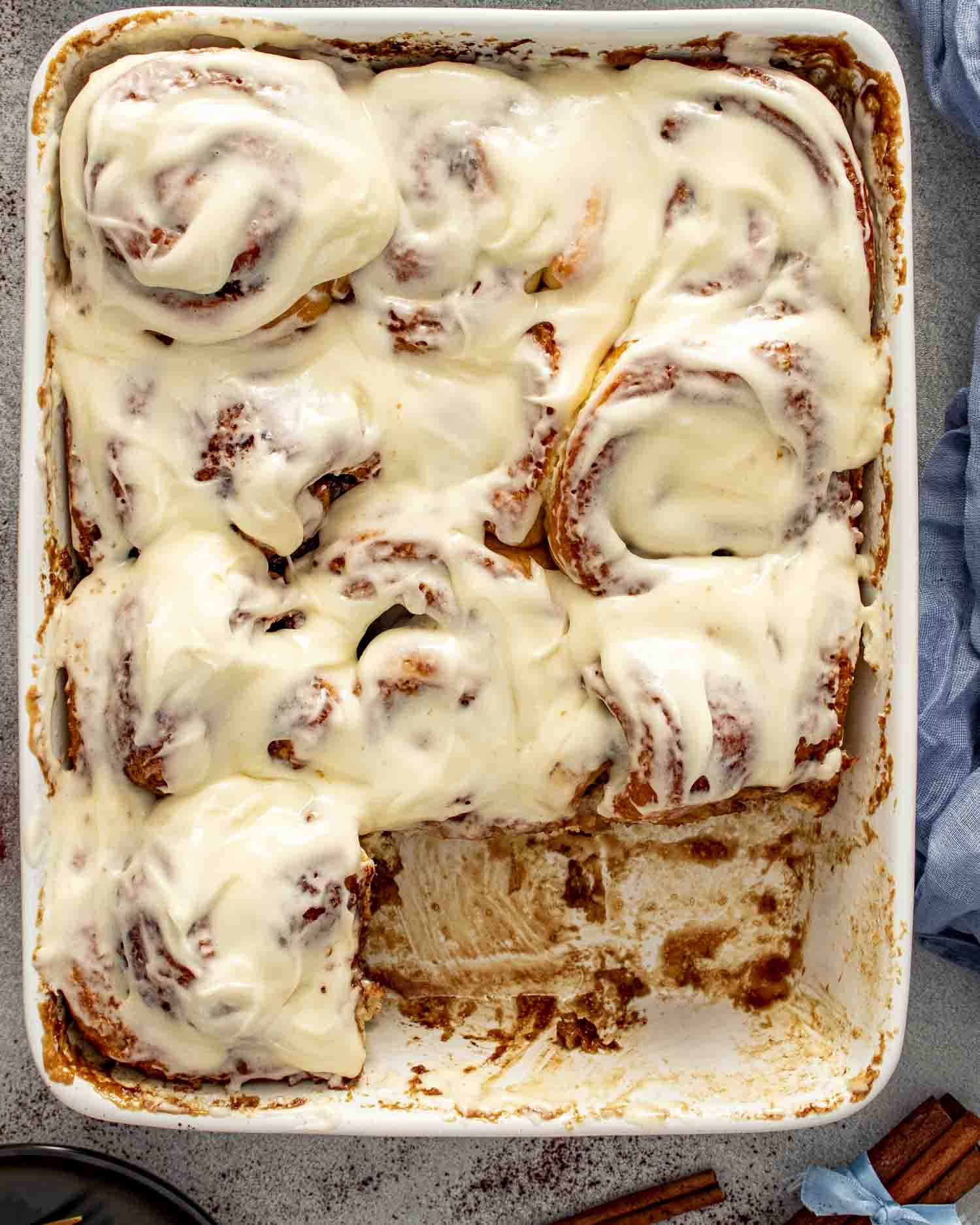 a pan of freshly made cinnamon rolls with icing.