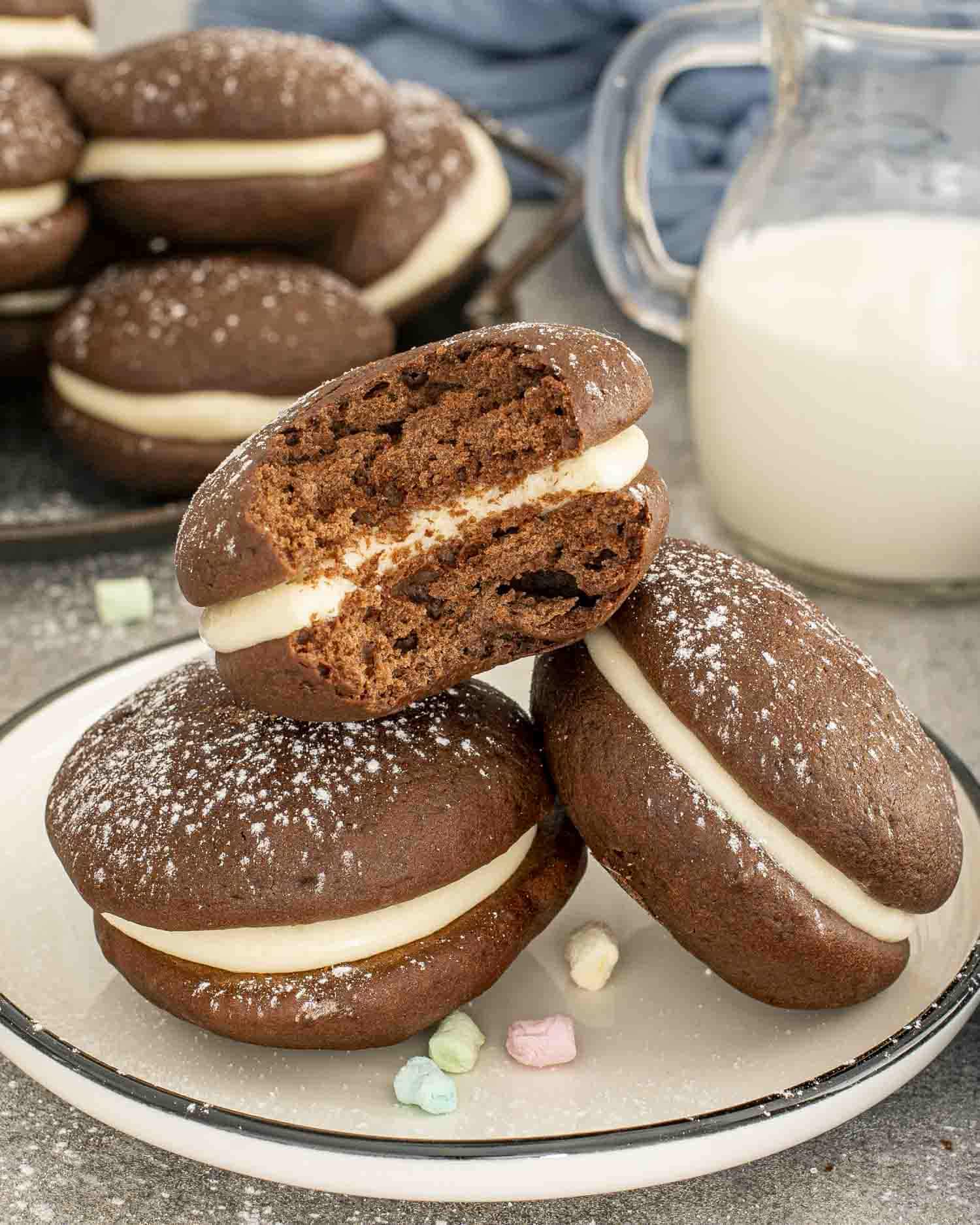 three whoopie pies on a plate with one having a bite taken out of it.