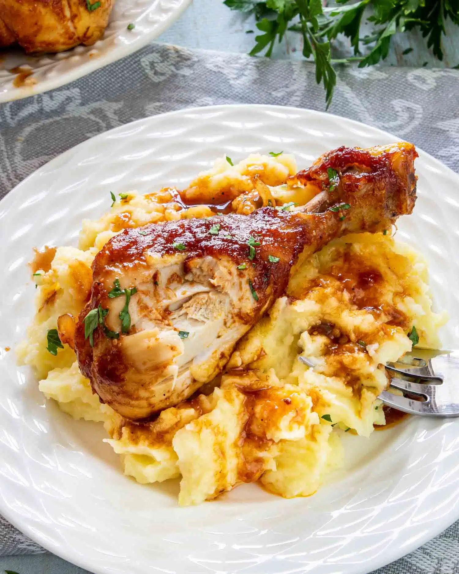 a bbq chicken drumsticks on a bed of mashed potatoes.