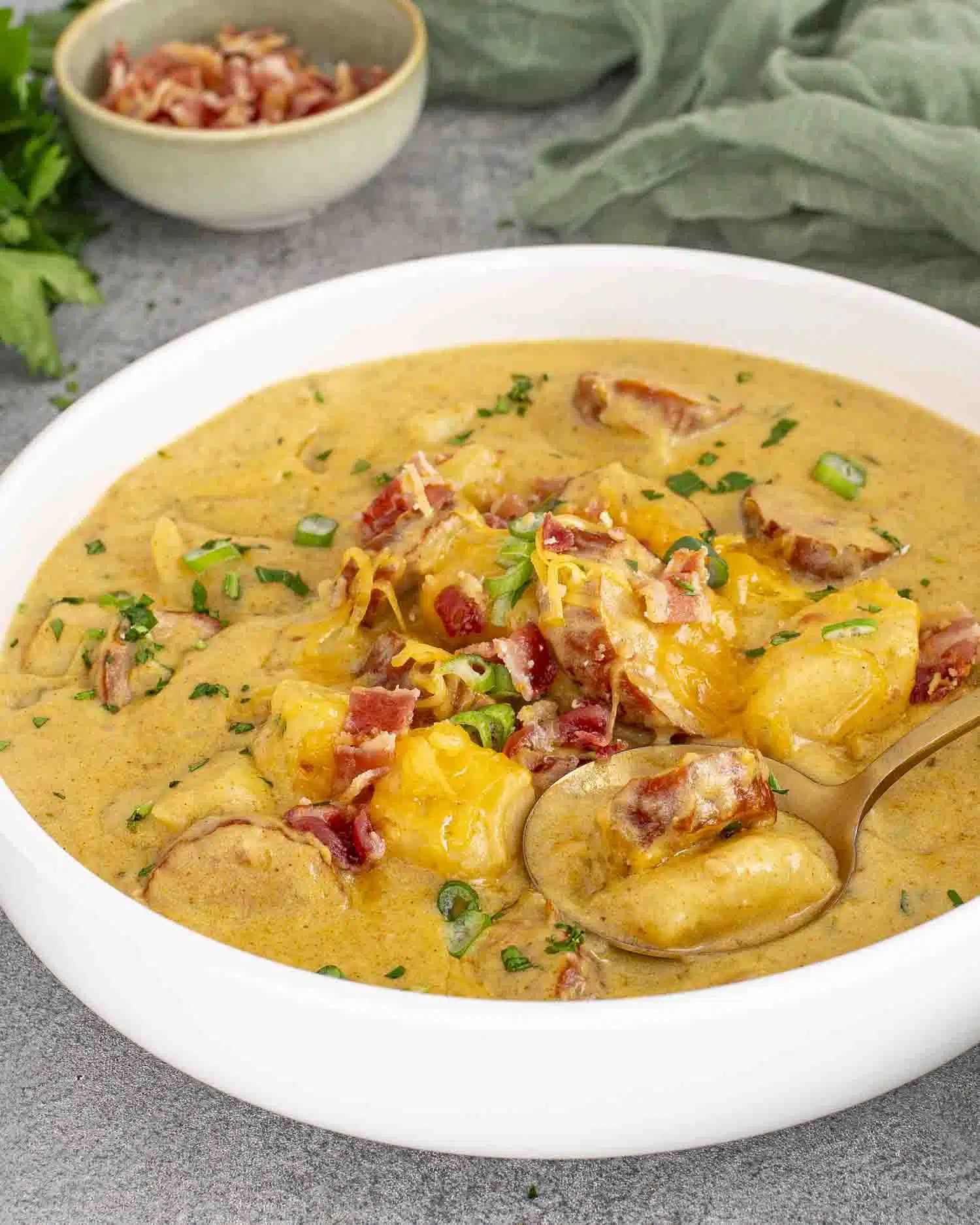 a white bowl loaded with cajun potato soup.