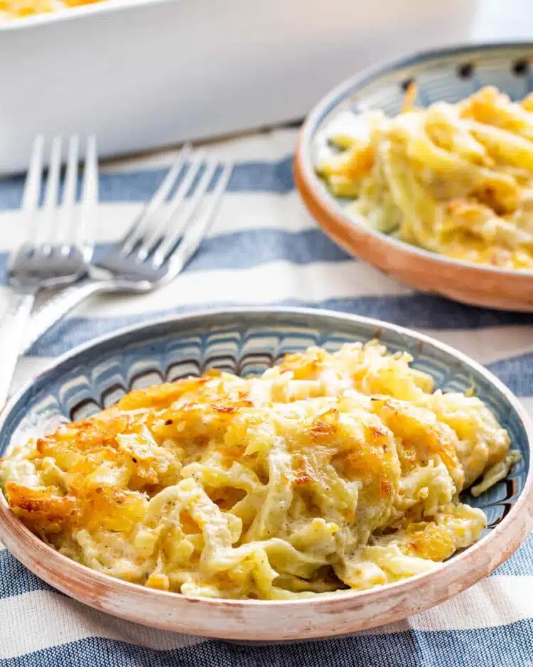 side shot of a couple plates loaded up with cheesy potato casserole