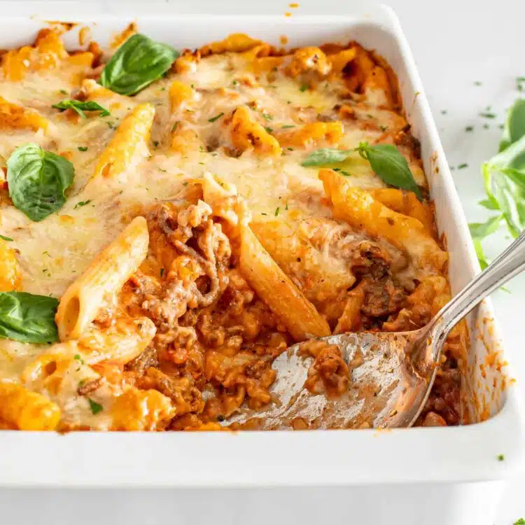 cheesy tomato beef bake in a white casserole dish.