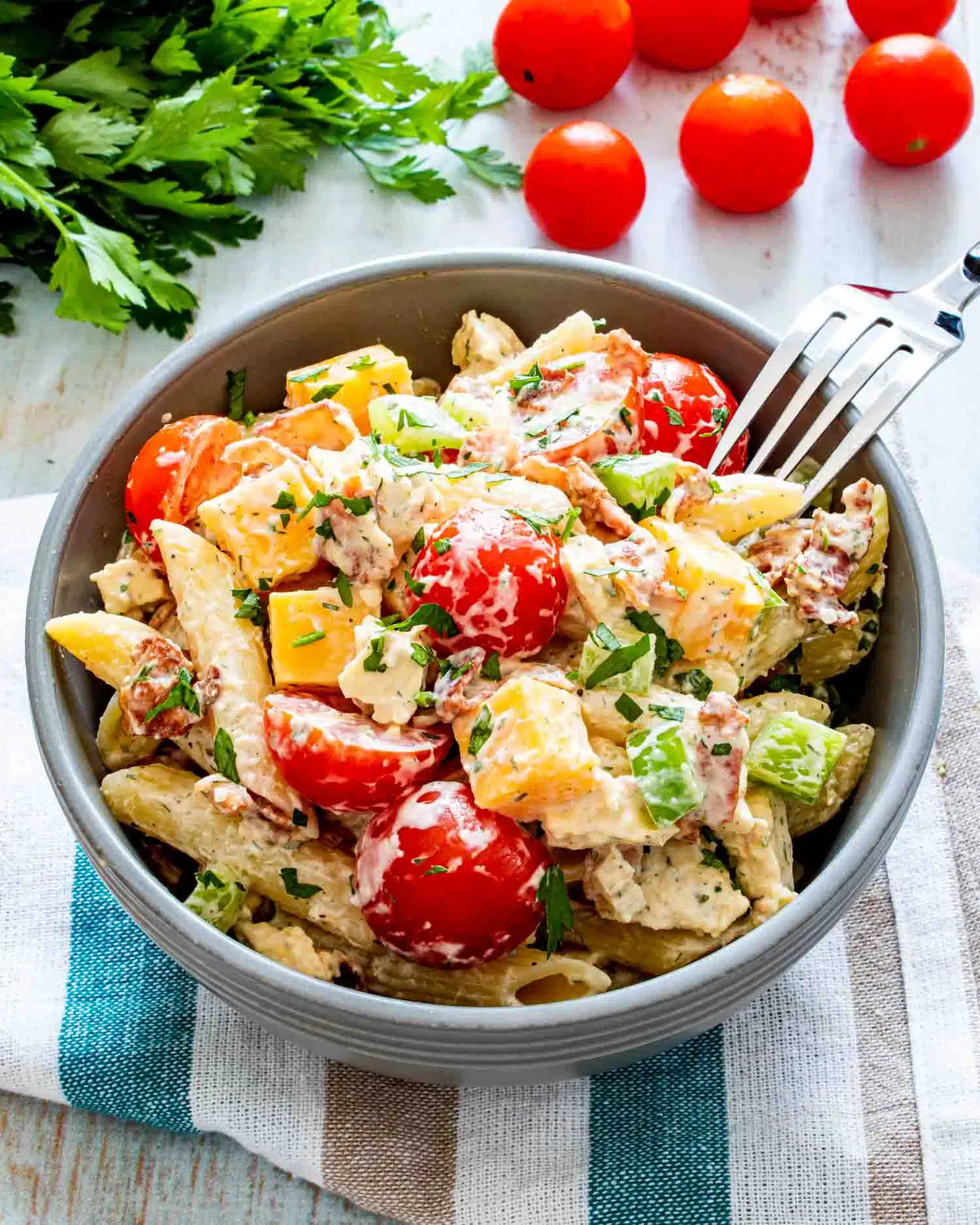 a serving of chicken club pasta salad in a blue bowl.