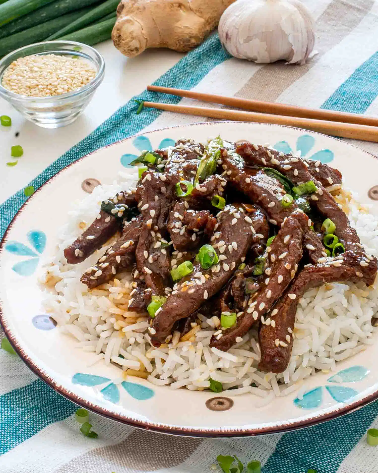 chinese sizzling beef on a bed of rice in a plate.
