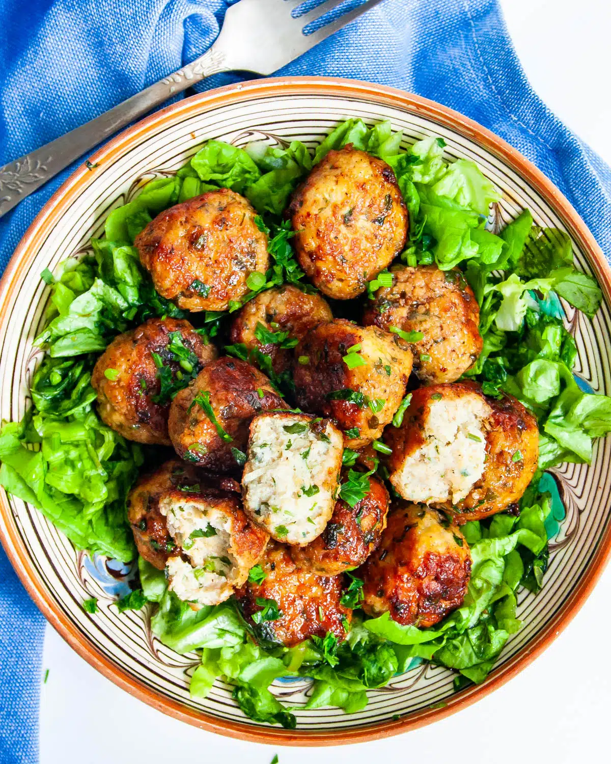 Firecracker Chicken Meatballs over a lettuce salad on a plate