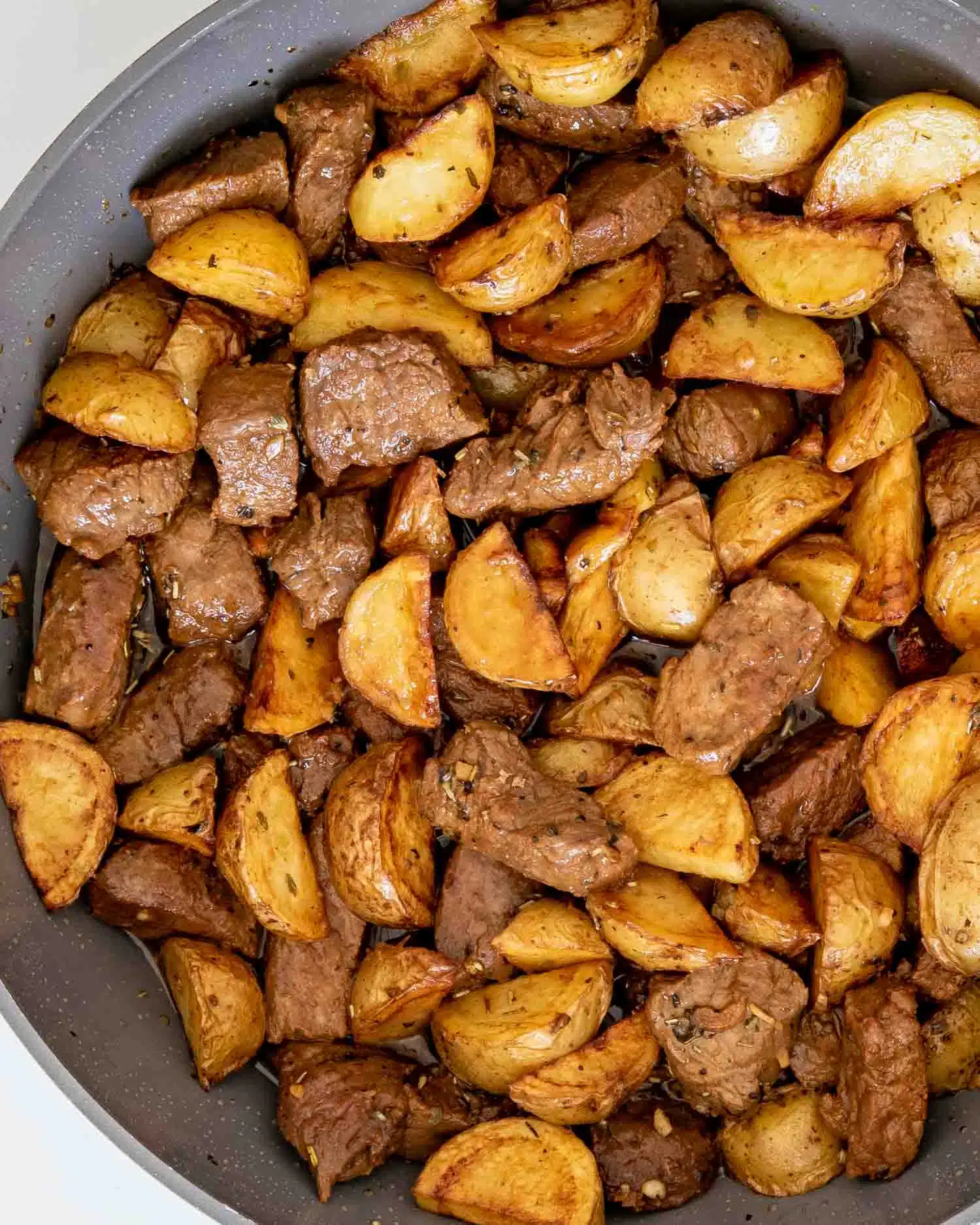 freshly made garlic butter steak and potatoes in a skillet.