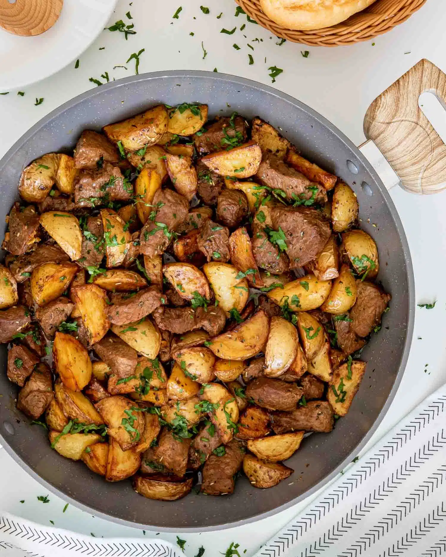 freshly made garlic butter steak and potatoes in a skillet.
