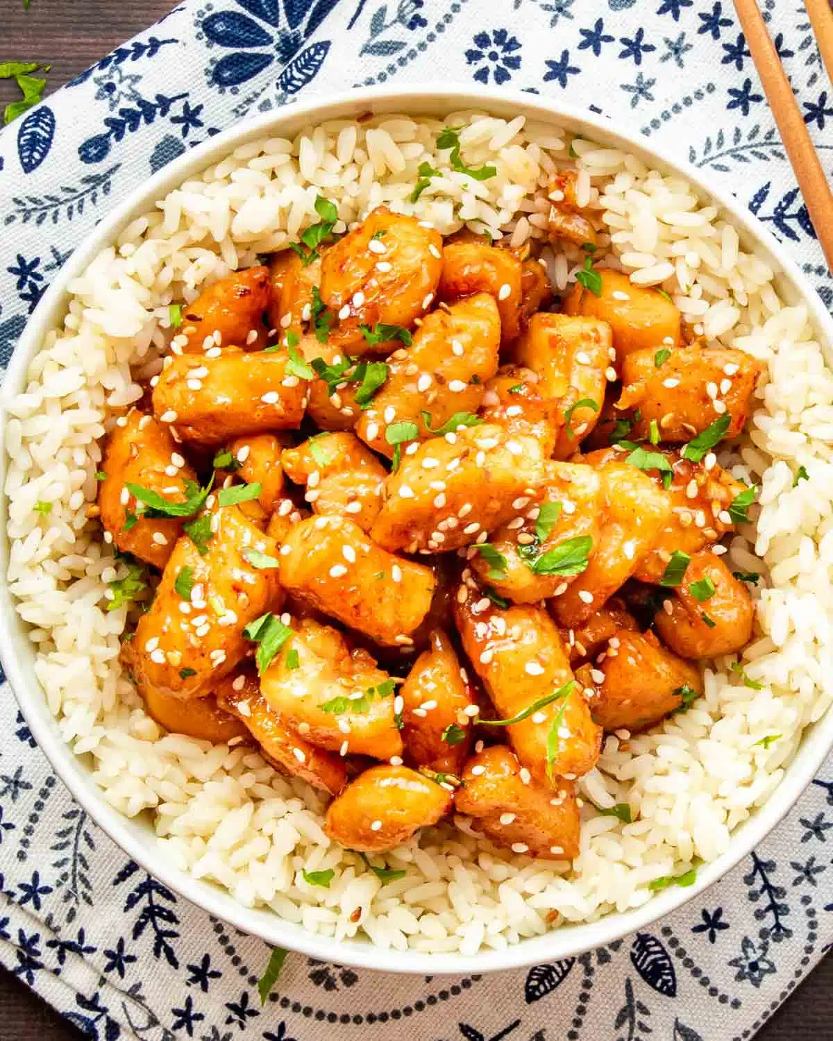 honey garlic chicken bites on a bed of rice in a bowl.