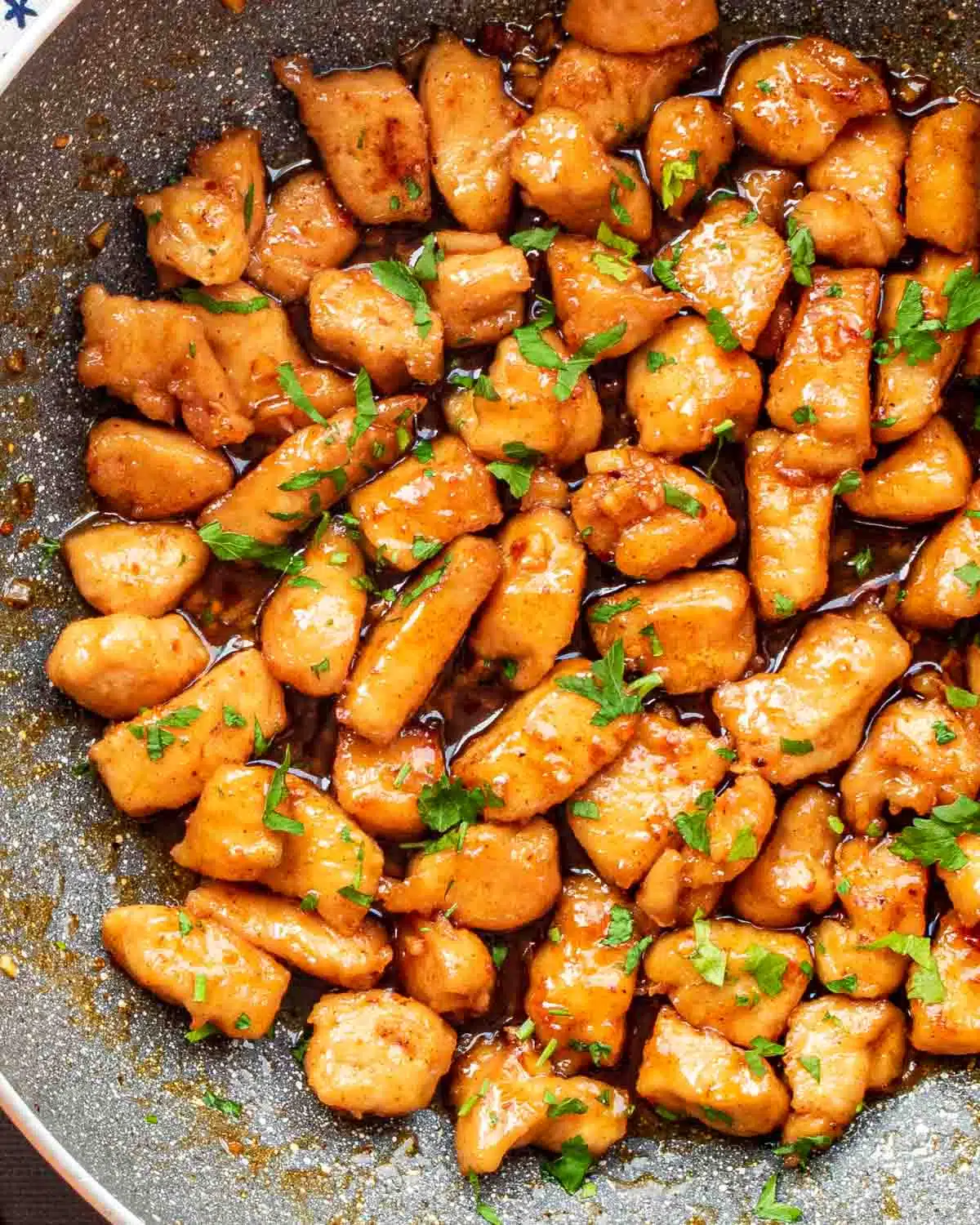 freshly made honey garlic chicken bites in a skillet.