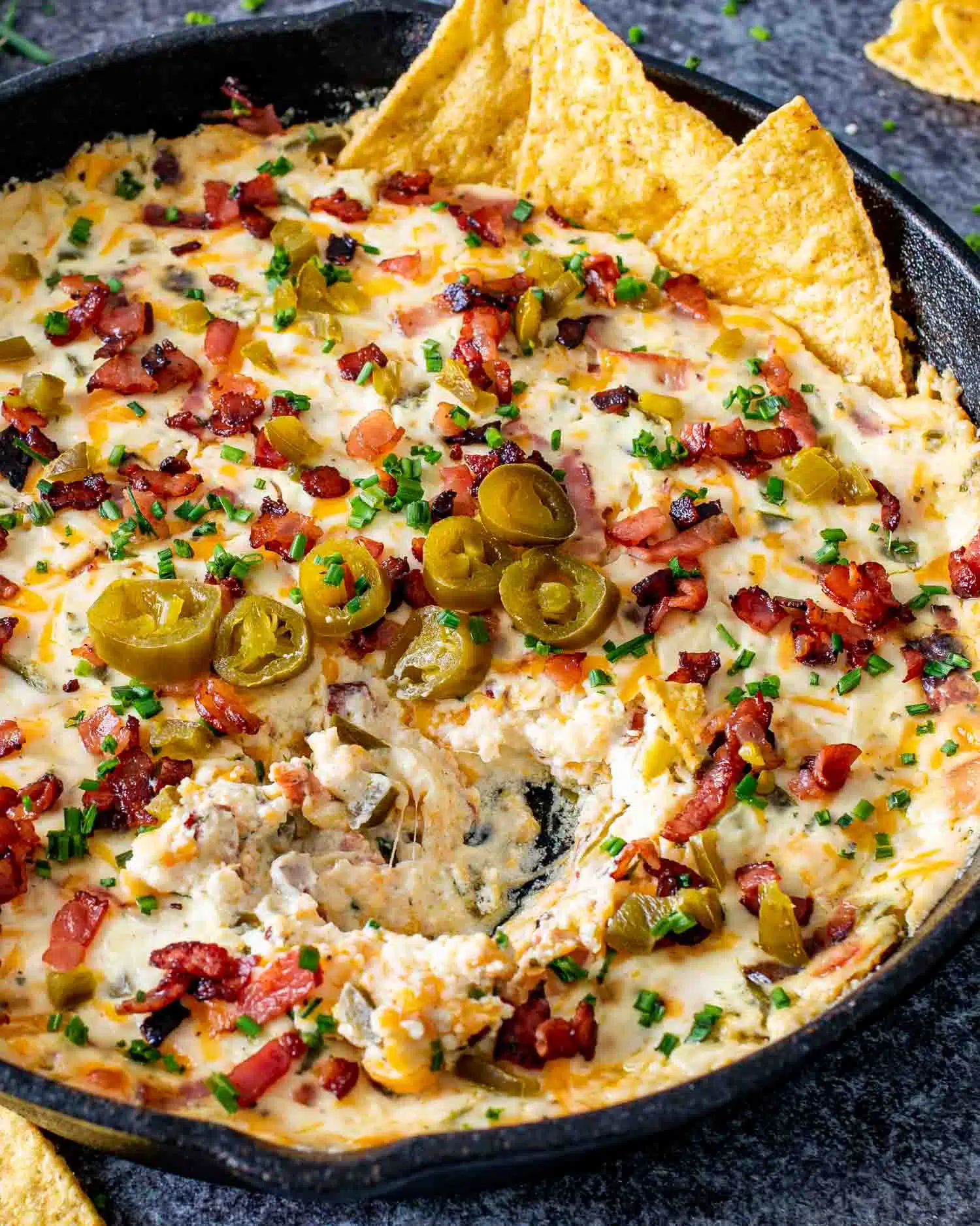 jalapeno popper dip in a black cast iron skillet fresh out of the oven.