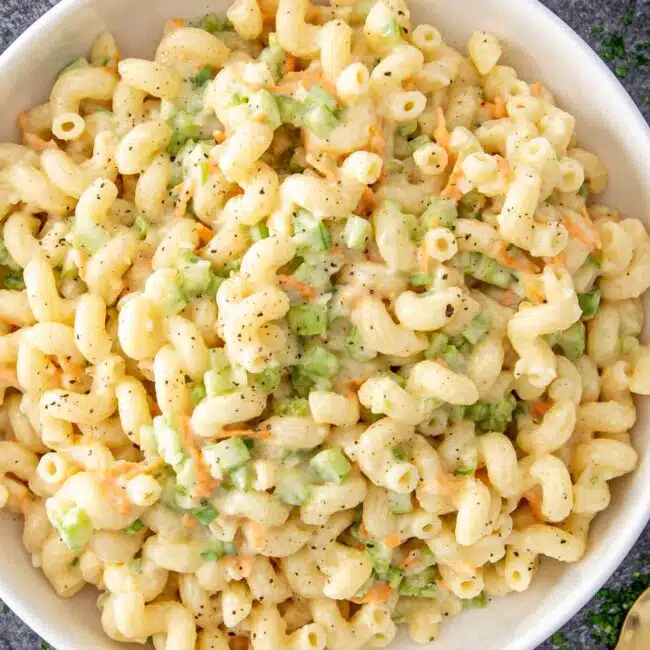 a white bowl with freshly made macaroni salad.