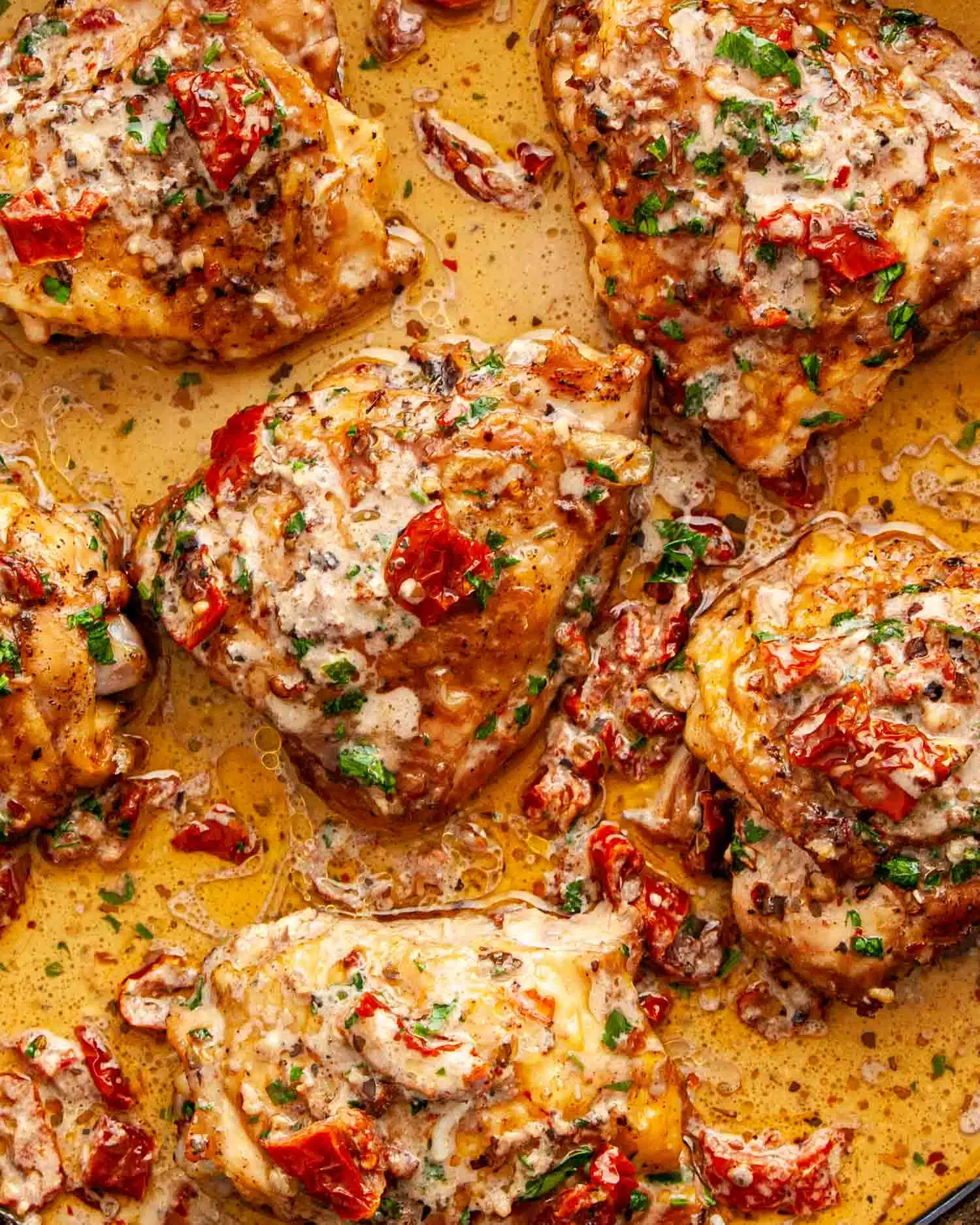 freshly made marry me chicken in a cast iron skillet garnished with parsley.