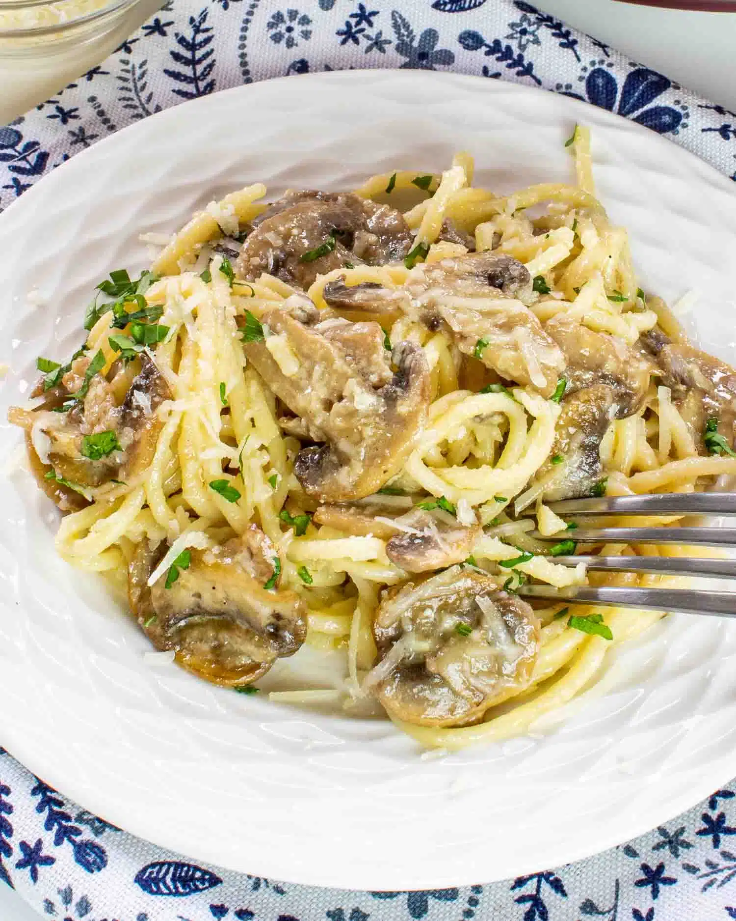 mushroom pasta in a plate with a fork in it.