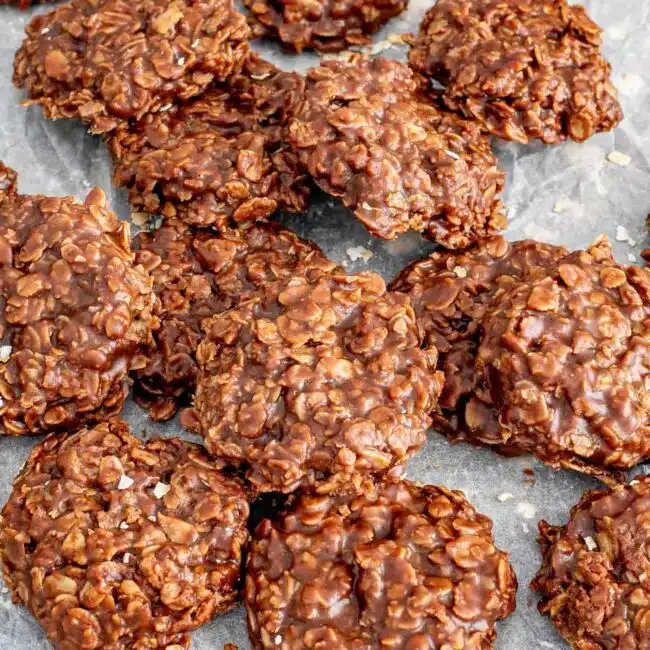a bunch of no bake chocolate oatmeal cookies on a piece of parchment paper.