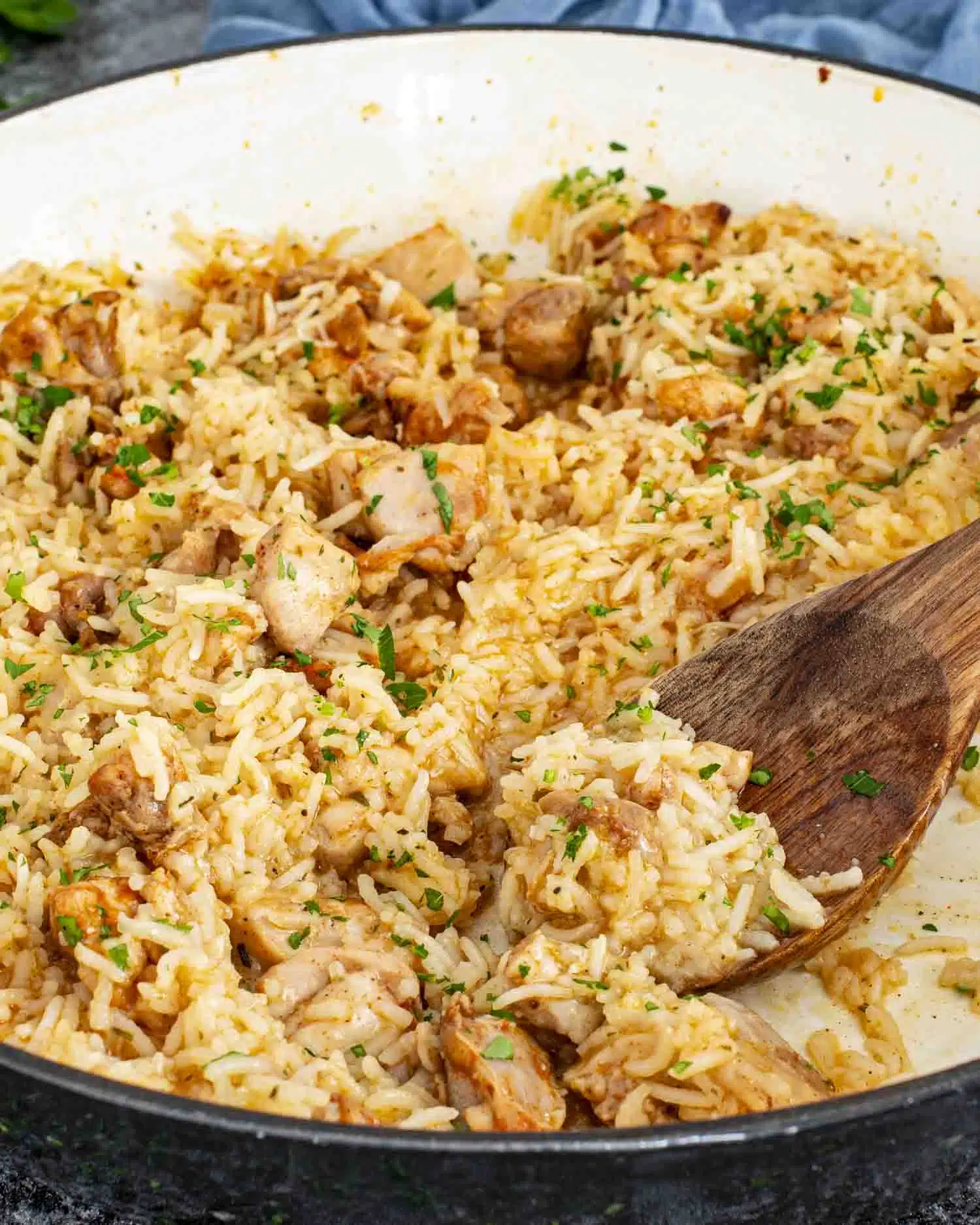 garlic butter chicken and rice in a braiser garnished with parsley.