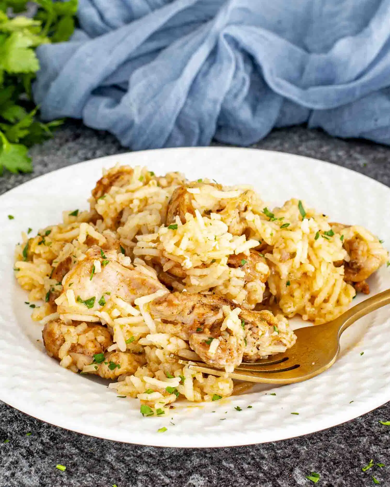 a serving of garlic butter chicken and rice on a white plate.