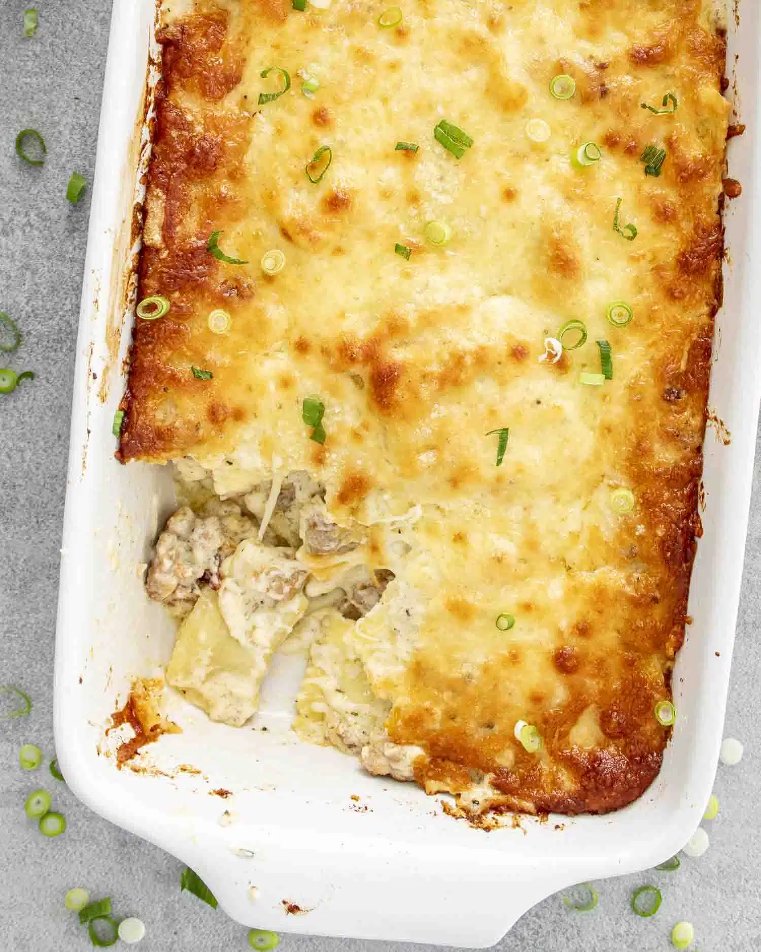 fresh out of the oven ravioli alfredo bake in a casserole dish.