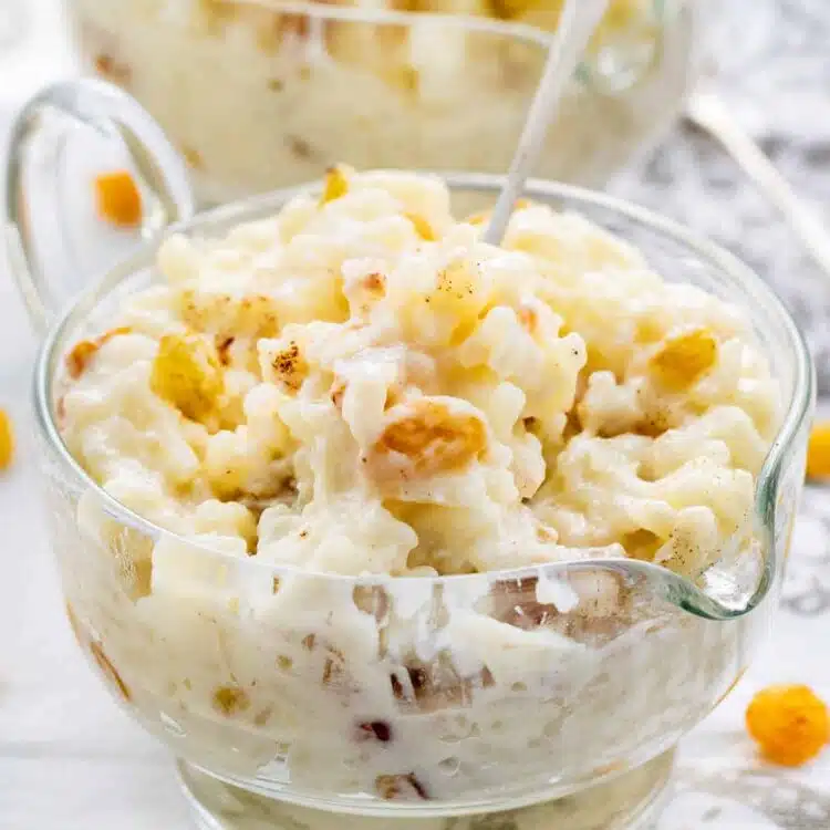freshly made rice pudding in a glass bowl with a spoon in it