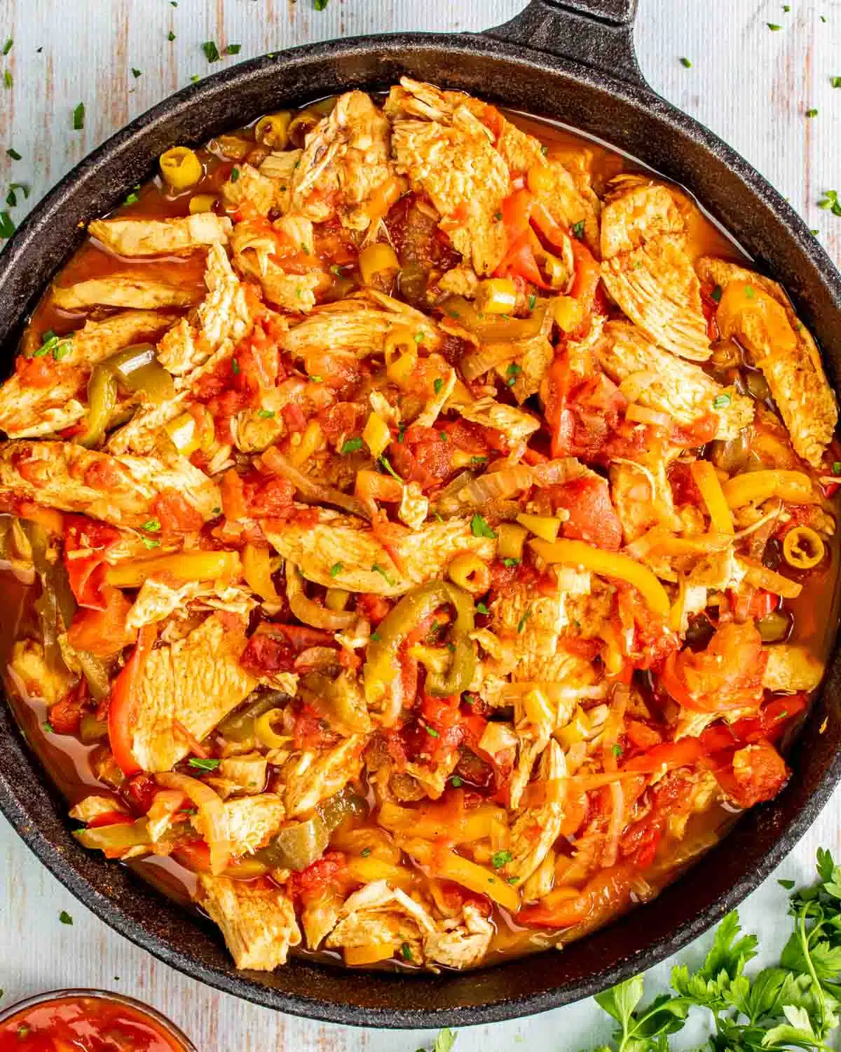 chicken fajitas in a black skillet.